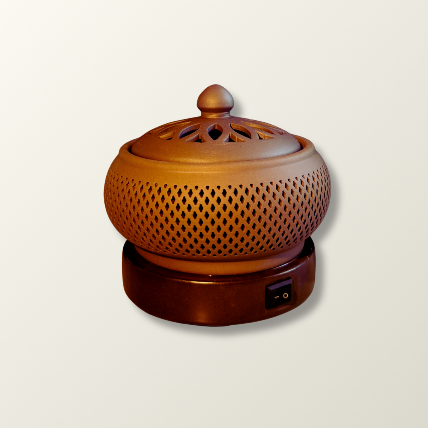 Ceramic electric incense burner with perforated design on a beige background